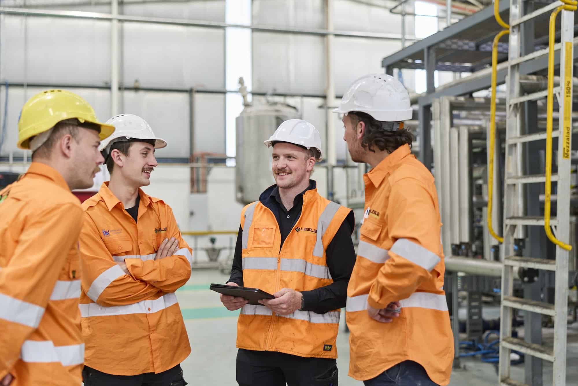 Leslie Electrical Services team in full PPE during a toolbox safety briefing on an industrial site